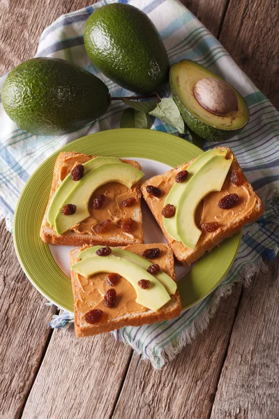 Sandwiches caseros con mantequilla de maní, pasas y aguacate en un — Foto de Stock