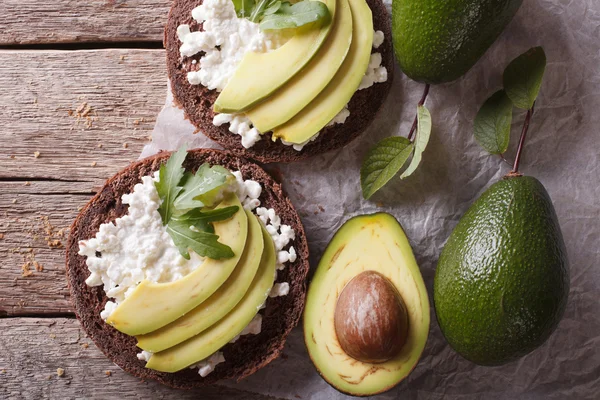 Toast met roomkaas en avocado close-up. horizontale boven vie — Stockfoto