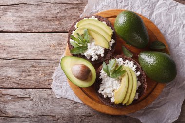 sandwiches with avocado, cheese and arugula. horizontal top view