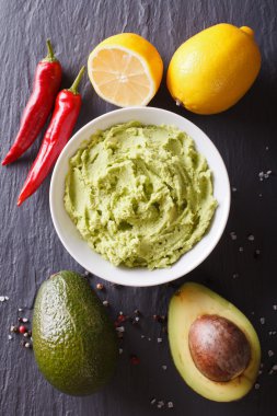 Delicious guacamole sauce and ingredients. vertical top view