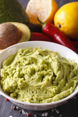 Mexican guacamole sauce in a bowl macro. Vertical