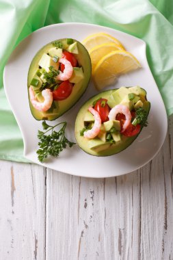 avocado filled with shrimp salad and vegetables. vertical top vi