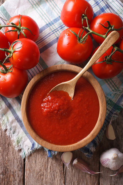 томатный соус с чесноком и базиликом в миске крупным планом. вертикальная t
