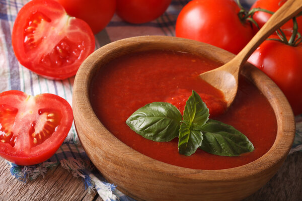красный томатный соус с базиликом в деревянной миске крупным планом. Горизонталь
