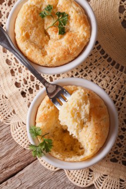 Cheese souffle in a ramekins close-up. vertical view from above clipart
