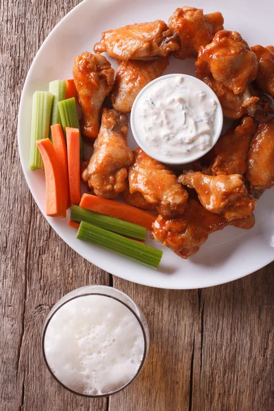 American fast food: buffalo wings and beer close-up vertical top