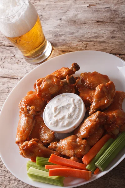 Buffalo wings och öl på bordet närbild vertikal — Stockfoto