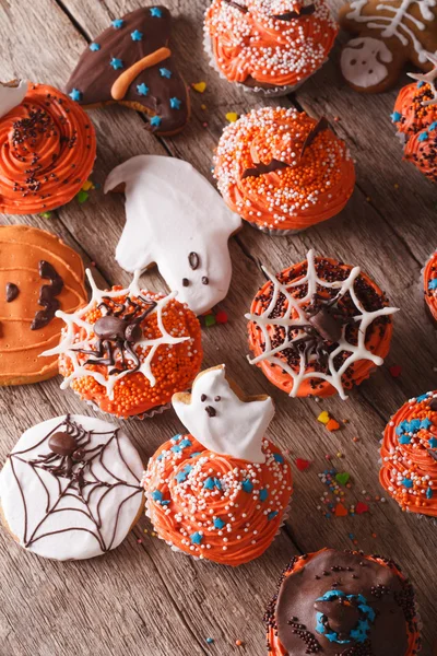 Bolinhos de Halloween e biscoitos de gengibre close-up. vertical para — Fotografia de Stock