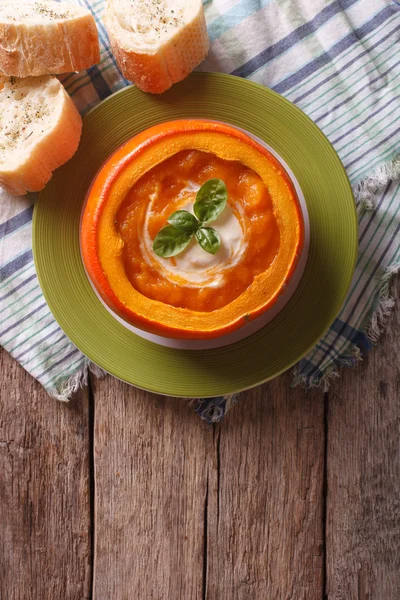 Soup with sour cream and basil in a baked pumpkin. vertical top — Stock Photo, Image