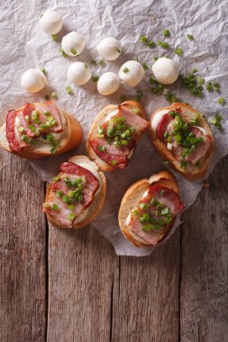 Delicious crostini with bacon and mozzarella cheese. vertical to