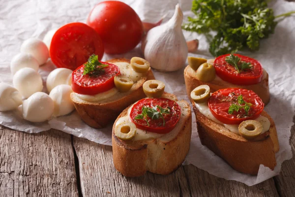 Bruschetta with tomatoes, olives and cheese close-up. horizontal — Zdjęcie stockowe