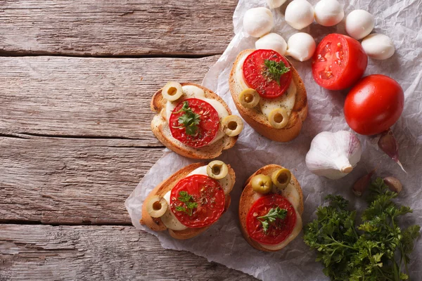 Crostini with tomatoes, olives and cheese. horizontal top view — 스톡 사진