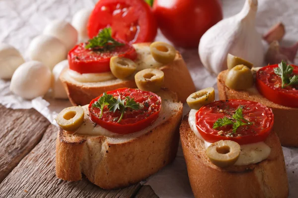 Crostini with baked tomatoes, olives and cheese close-up. Horizo — Zdjęcie stockowe