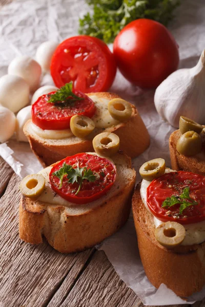 Crostini with baked tomatoes, olives and cheese close-up. vertic — 스톡 사진
