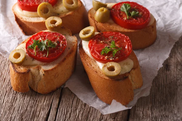 Bruschetta with baked tomatoes, olives and mozzarella. horizonta — Zdjęcie stockowe