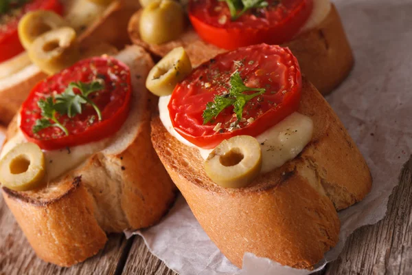 Crostini con tomates, aceitunas y mozzarella macro. horizontal —  Fotos de Stock