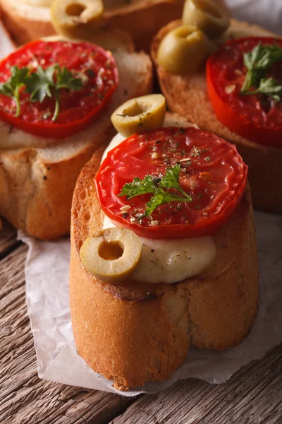 Crostini con tomates, aceitunas y mozzarella macro. Vertical —  Fotos de Stock