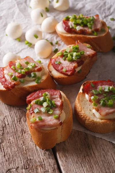 Crunchy crostini with bacon and mozzarella cheese close-up. vert — Stock fotografie