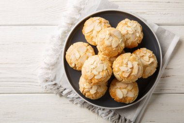 Tahta bir masadaki tabakta badem gevrekli çıtır kurabiyeler. Yukarıdan yatay üst görünüm