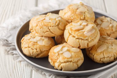 Tahta bir masanın tepsisinde kıtır kıtır bademli kurabiyeler. Yatay