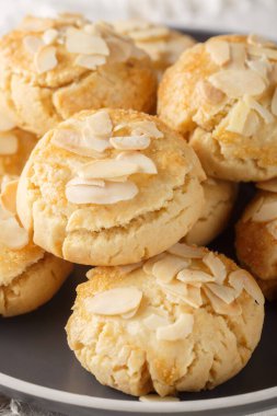 Badem gevreği bisküvileri masanın üzerindeki tabağa yakın çekim. Dikey