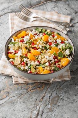 Kış Nar Portakallı kinoa salatası, ıspanak, feta ve fıstıklı masaya yakın çekim. Dikey