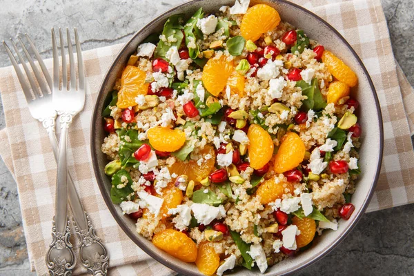Lezzetli, vitamin zengini kinoa salatası ıspanak, feta, mandalina, nar ve şam fıstığı ile masada yakın plan. Yukarıdan yatay üst görünüm