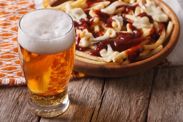 Comida canadiense: cerveza y papas fritas con salsa de cerca. horizontal — Foto de Stock