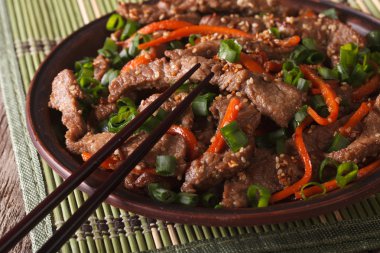slices of beef fried with sesame seeds and carrots closeup. hori