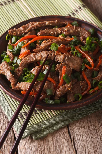 Slices of beef fried with sesame seeds and carrots closeup. Vert — 图库照片