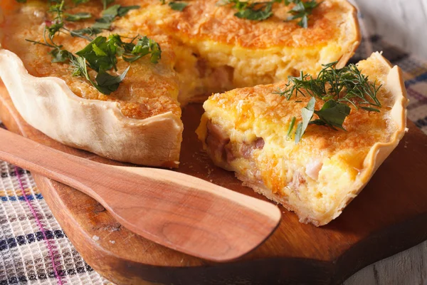 Sliced quiche with cheese, eggs and bacon close-up on a board. H — Stock Photo, Image