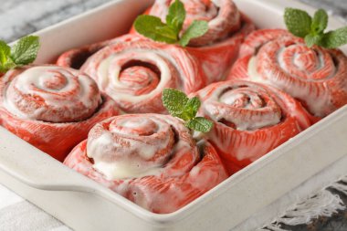 Şenlikli pembe tarçınlılar, beyaz kremalı tarçınlı börekler, bir masada yakın plan bir tavada. Yatay