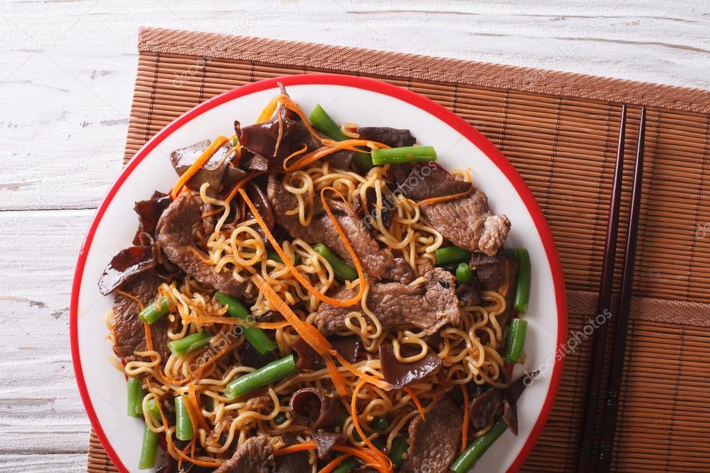 Lo mein with beef, muer and vegetables closeup. Horizontal top v
