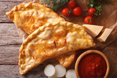 Pizza calzone closeup bir kağıt ve malzemeler. Yatay üst