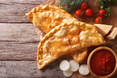 Pizza calzone bir kağıt ve malzemeler. Yatay Üstten Görünüm
