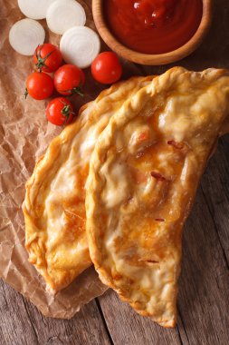 İtalyan calzone closeup bir kağıt ve malzemeler. Dikey üst