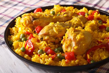 Paella with chicken meat and vegetables closeup. horizontal clipart