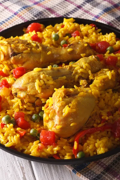 Paella met kip benen en groenten close-up. Verticaal — Stockfoto