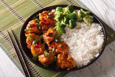General Tso's chicken with rice, onions and broccoli.  horizonta clipart