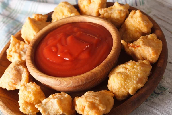 Fast food: crispy popcorn chicken fillet with sauce close-up