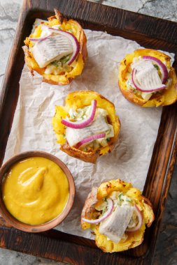 Yumurta salatasıyla doldurulmuş ev yapımı fırınlanmış patates bardakları ve masanın üzerindeki tahta tahtaya yakın plan hardal sosuyla servis edilen tuzlanmış ringa balığı. Yukarıdan dikey üst görünüm