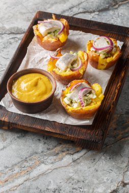 Salata ve ringa fileto ile doldurulmuş İskandinav usulü fırında patatesler. Masadaki tahta tahtaya yakın plan. Dikey