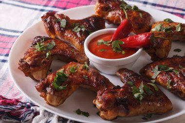 Plaka yakın çekim üzerinde chili soslu ızgara tavuk kanatları. Hori