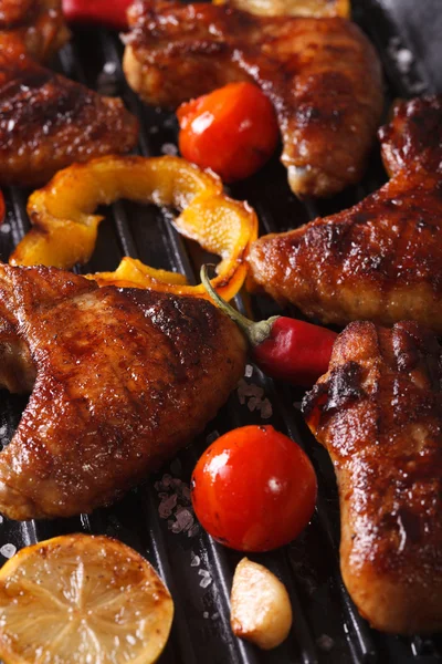 Chicken wings with vegetables in a grill macro. Vertical — Stock Photo, Image