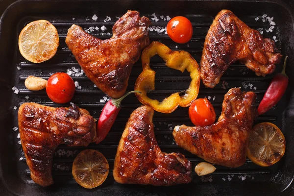 Chicken wings with vegetables in a grill closeup. horizontal top — Stock Photo, Image
