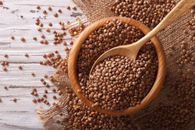 Bir ahşap kase çiğ kahverengi mercimek. Yatay Üstten Görünüm