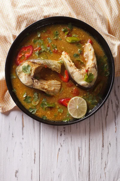 Spicy fish curry with cilantro on the table. vertical top view — Stock Image Spicy fish curry with cilantro on the table. vertical top view Royalty Free Stock Photos