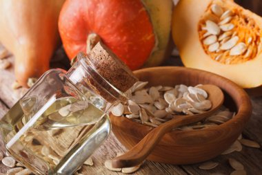 masaya bir şişe makroda taze kabak çekirdeği yağı. Horizonta