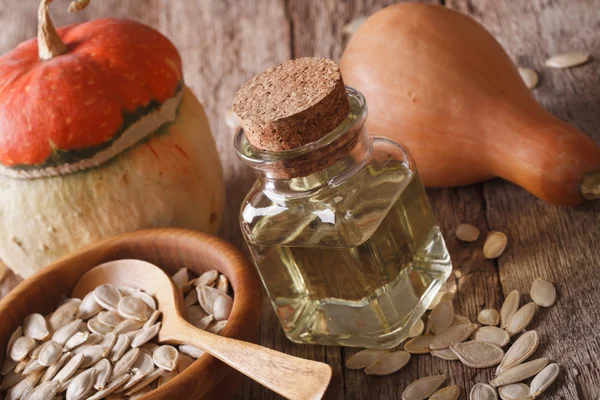 Pompoenpitten olie in een fles macro op de tafel. horizontale — Stockfoto