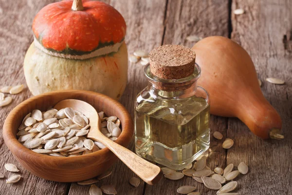 Pumpkin seed oil in a bottle closeup on the table. horizontal — Stock Photo, Image